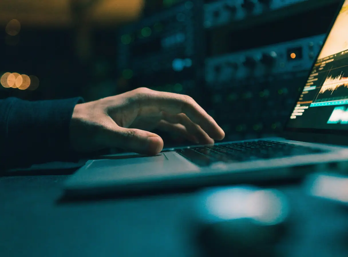 Hand dragging a file on a laptop running a DAW